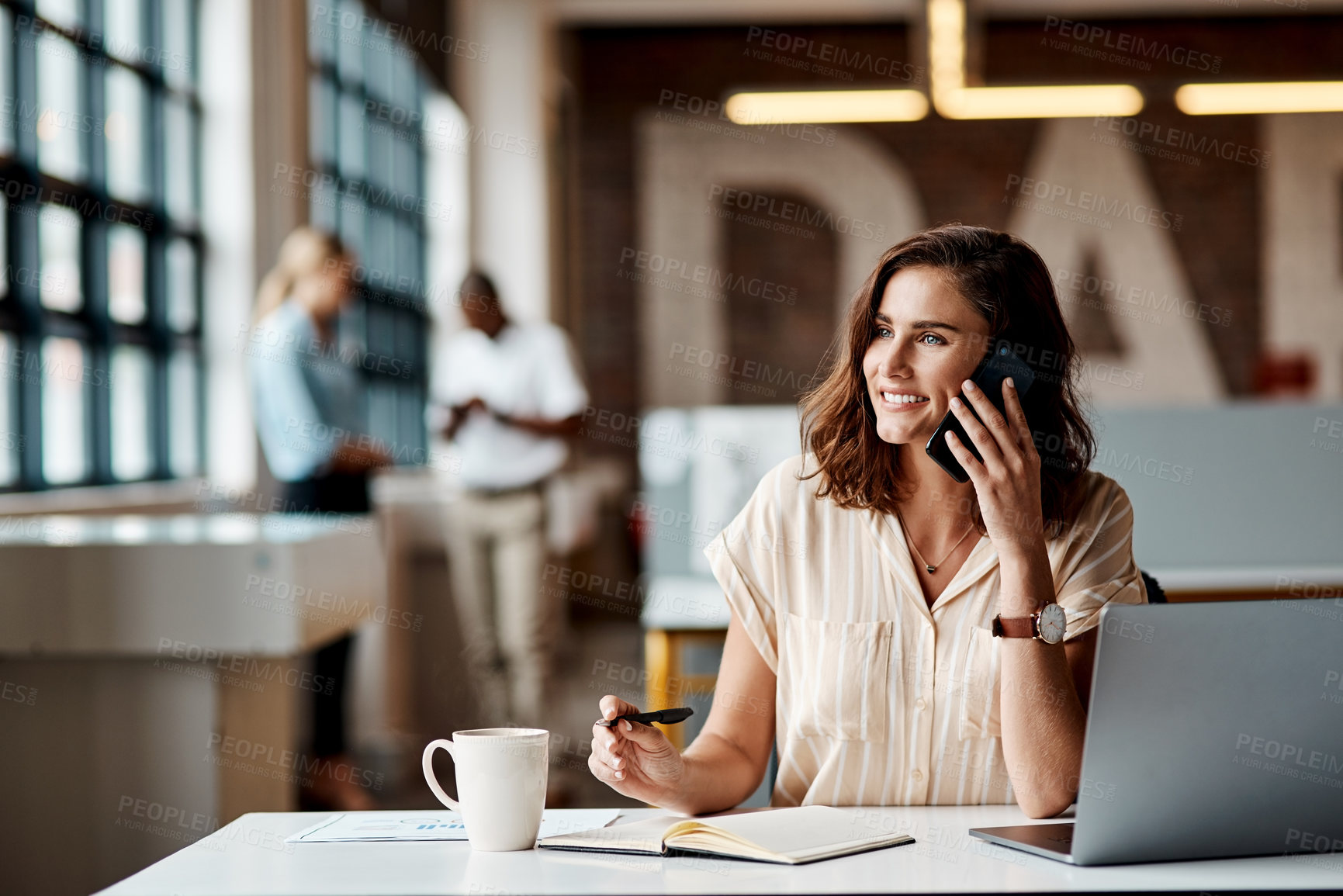 Buy stock photo Shot of a young businesswoman using a laptop and smartphone in a modern office