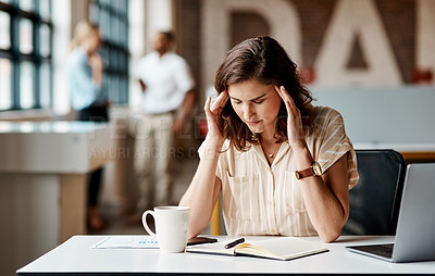 Buy stock photo Shot of a young businesswoman looking stressed out while using a laptop in a modern office