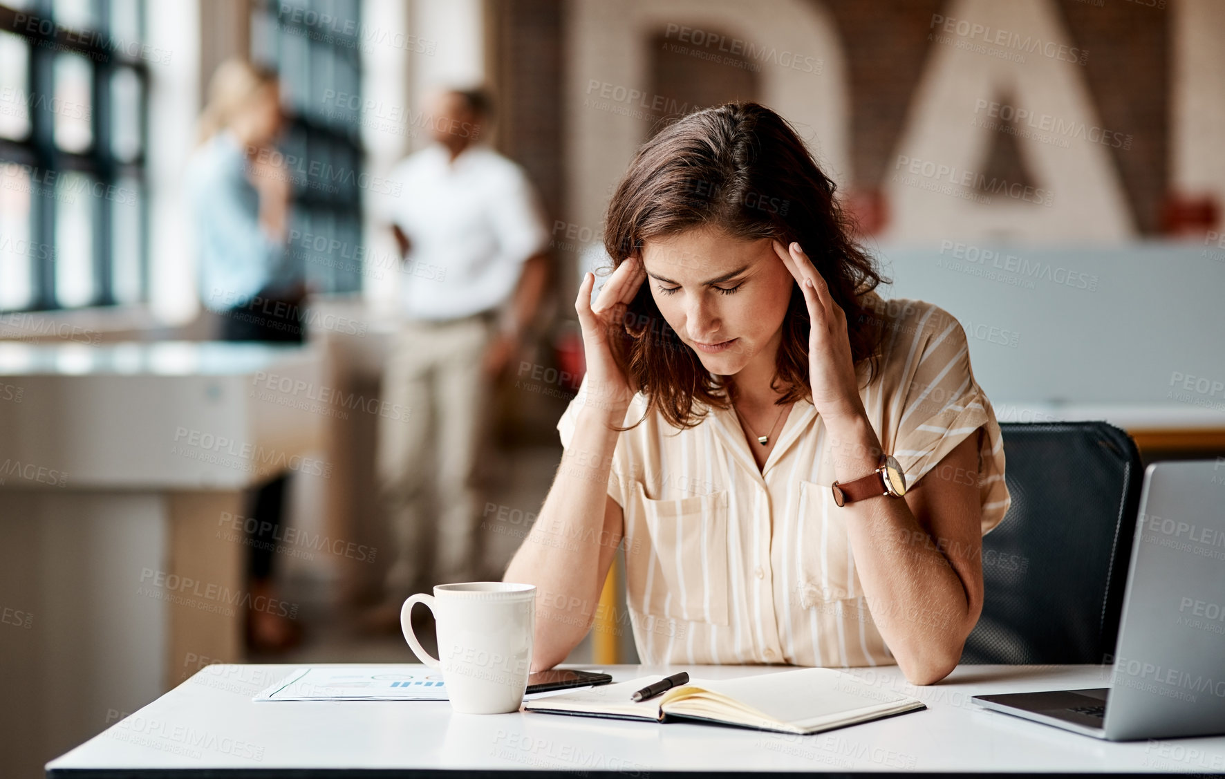 Buy stock photo Shot of a young businesswoman looking stressed out while using a laptop in a modern office
