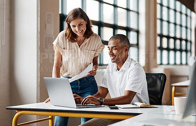 Buy stock photo Shot of a young businessman using a laptop with his colleague in a modern office