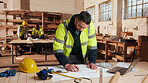 Carpentry, man and blueprint review in warehouse for shopfitting, custom furniture design and staff. Tech, carpenter and floor plan in workshop for woodwork project, cabinetry layout and evaluation