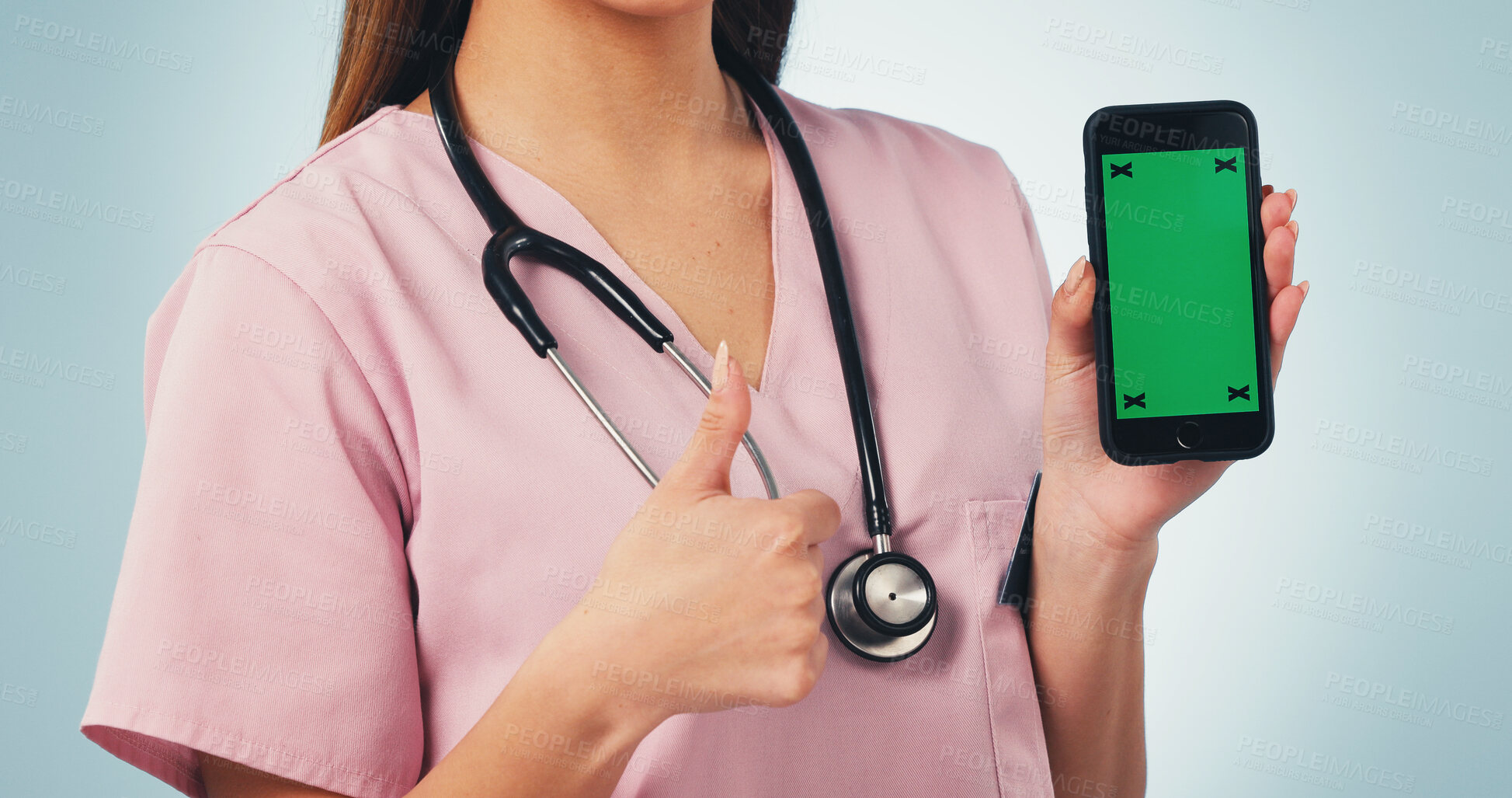 Buy stock photo Nurse, hands or thumbs up with phone green screen for advertising on a blue studio background. Female person, healthcare worker or smartphone display with like emoji for UI, UX or app on mockup space