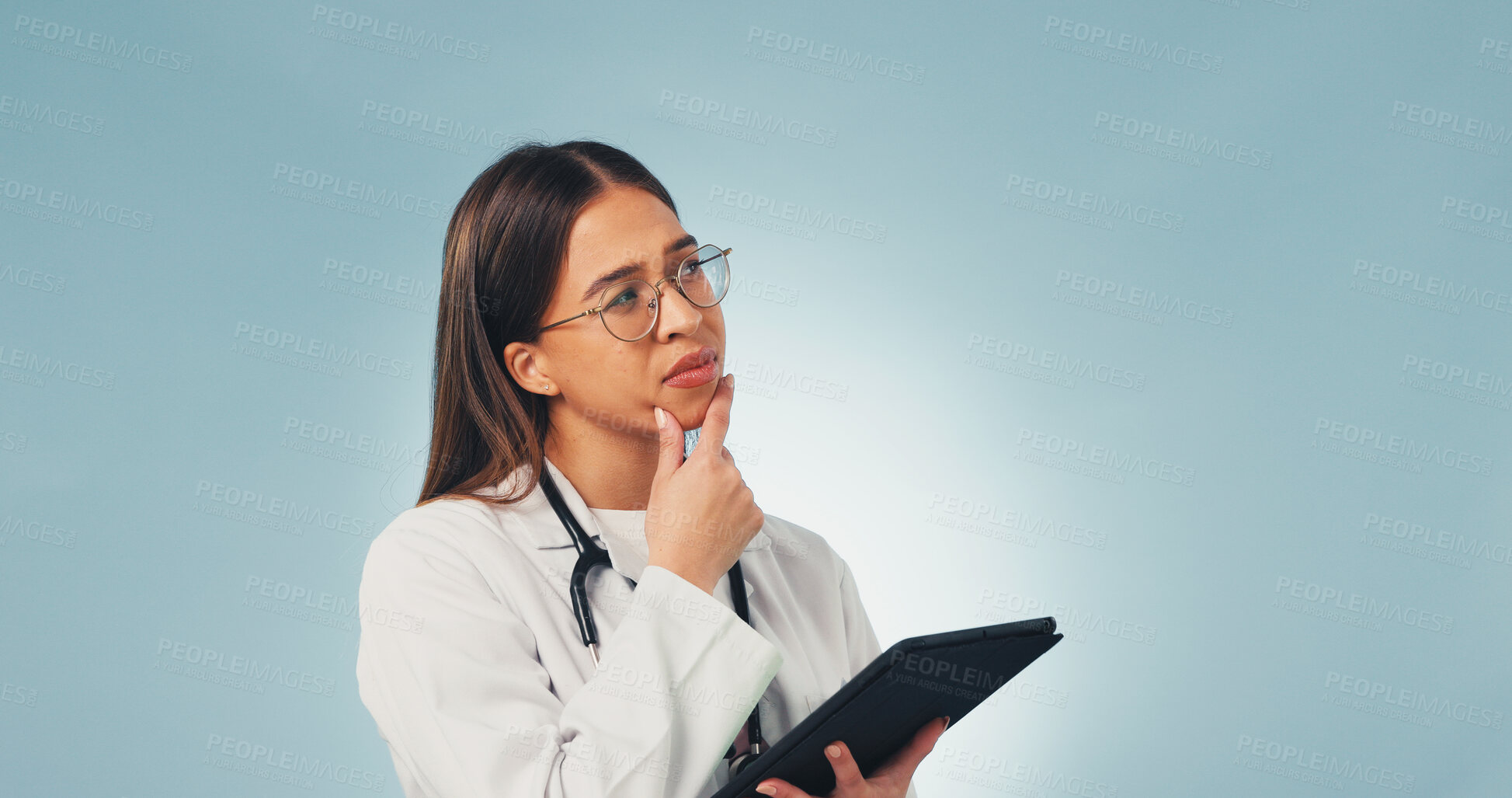 Buy stock photo Doctor, woman and thinking in studio with tablet, medical research and planning for diagnosis decision. Healthcare worker, person and reflection with tech, problem solving or space on blue background