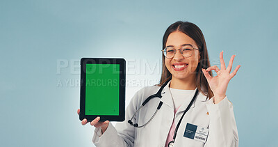Buy stock photo Green screen, perfect and face of doctor with tablet in studio for medical research or telehealth. Happy, woman and portrait of healthcare worker with ok gesture for technology on blue background.