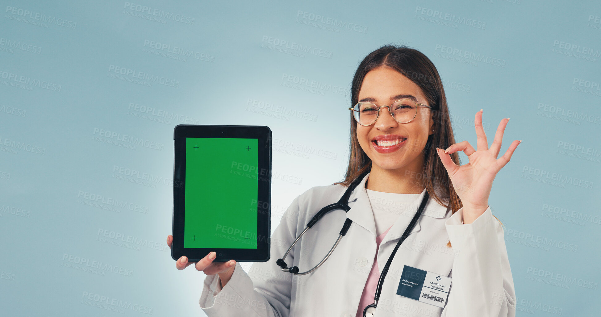 Buy stock photo Green screen, perfect and face of doctor with tablet in studio for medical research or telehealth. Happy, woman and portrait of healthcare worker with ok gesture for technology on blue background.