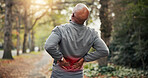 Old man, stretching and back pain in nature for fitness, accident and sprain from exercise. Senior person, discomfort and red glow at park with joint inflammation, muscle injury and training burnout