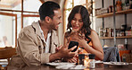 Couple, laughing and bonding with phone in restaurant, love and watching funny video on social media. Happy people, online and relax with mobile in diner, date and streaming comedy with technology