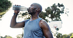 Sports, man and drinking water on basketball court for exercise recovery, wellness or health on break. African person, bottle and mature athlete with electrolytes, fitness and hydration outdoor