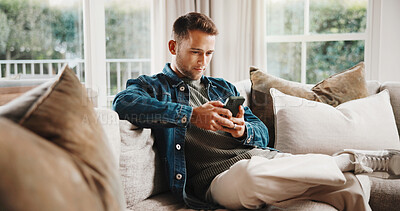 Buy stock photo Phone, relax and man on sofa in home with texting, chatting or social media on mobile app. Notification, chilling and person on cellphone for reading online blog for research in living room at house.
