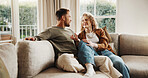 Couple, relax and talking at house with smile, love and partner support for bonding together. Happy, people and unwind in lounge with spouse, comfortable and relationship commitment for weekend break