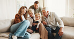 Smile, family and toddler at house with phone, baby pictures and watching cartoon for bonding. Parents, grandparents and child in lounge with mobile, streaming video and browsing for nursery rhymes 