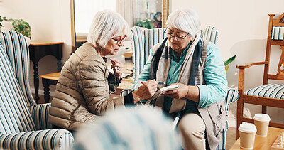 Buy stock photo Old women, relax and reading at house with crossword, word search and quiz for health. Senior people, helping or book in lounge with sudoku games, problem solving and puzzle activity for brain teaser