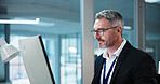 Business, man and smile with computer in office for risk assessment, finance news or insight. Review, mature financial advisor and tech at agency for market tracking, ai scenario planning and reading