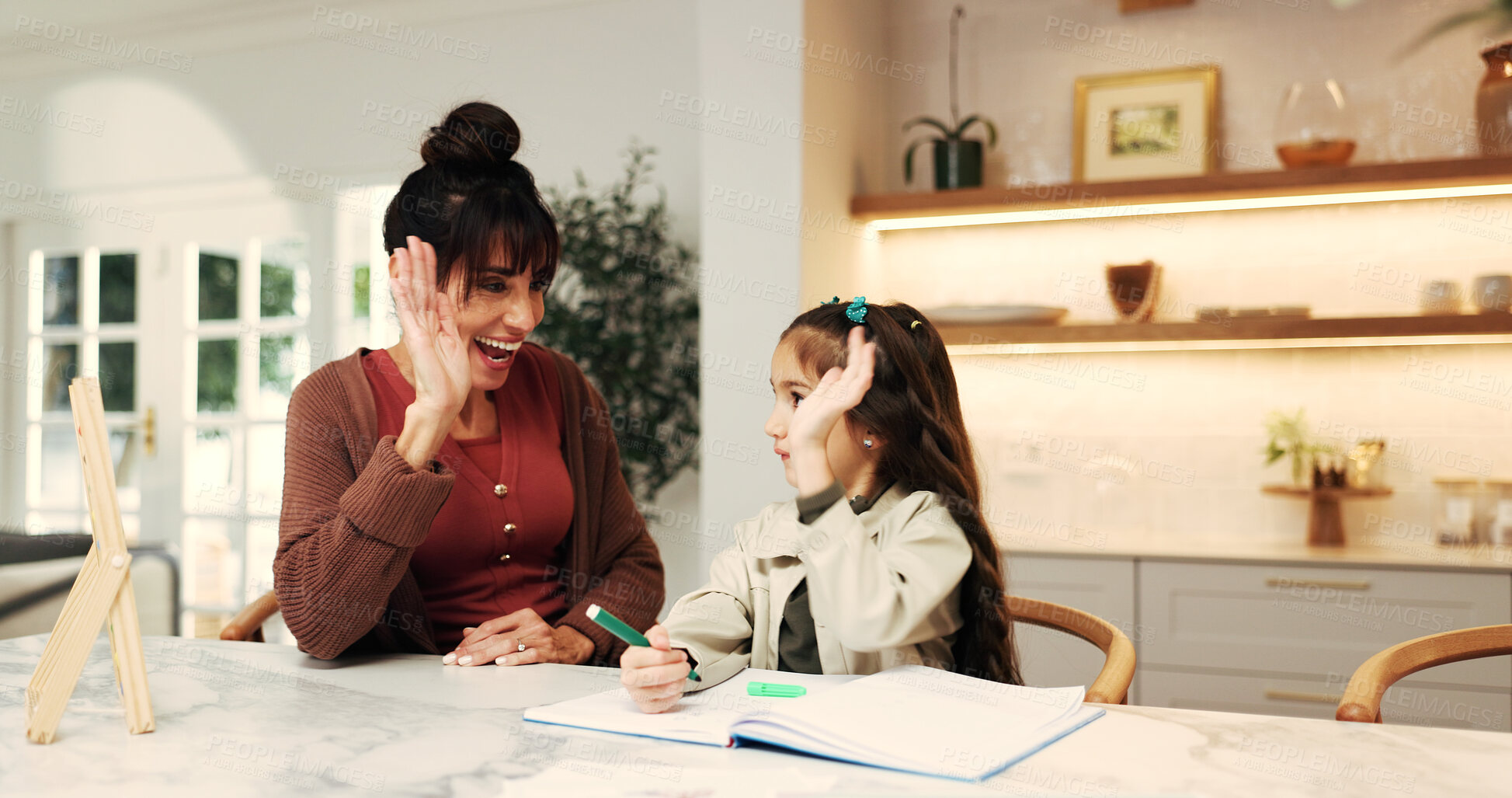 Buy stock photo Girl, mother and high five with homework, support and book for celebration with education in home. People, mom and child for assignment success, learning and studying for development at family house