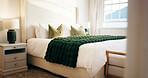 Empty, room and bed in hotel, hospitality and furniture with decor, real estate and interior design. Luxury, accommodation and cozy blanket in bedroom, comfort and tidy motel or travel destination