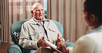 Therapy, talking and senior man in office for grief counseling, healing and help for mental health. Retirement, psychologist and elderly person in session for support, notes and explain trauma