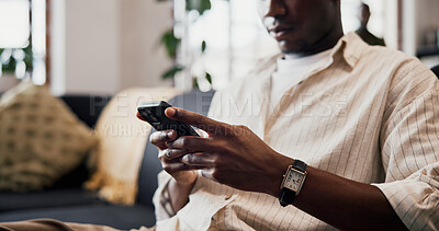 Buy stock photo Hands, phone and texting on couch in home with chat, contact and scroll with post in living room. African man, smartphone and typing with mobile app, notification or social network at apartment