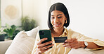 Credit card, phone and woman on sofa for online shopping, digital purchase and internet banking. Happy, home and person on mobile app with debit info for ecommerce, subscription and web discount