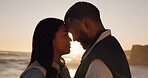 Love, sunset and couple at beach with connection, loyalty and care on summer vacation getaway. Man, woman and forehead touch with happy partner by sea for relationship romance or support on holiday