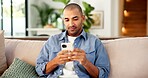 Phone, relax and man on sofa in home for texting, email or social media on mobile app in living room. Technology, typing and person on cellphone for chatting online with weekend break in house.