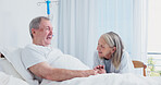 Senior, couple or happy holding hands at hospital bed for recovery support, discharge news or relief. Marriage, elderly people or talk in geriatric ward for positive test results, healing or optimism