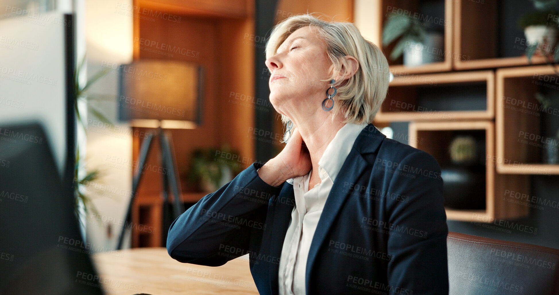 Buy stock photo Mature, businesswoman and neck pain in office with computer, burnout and fatigue from accounting job. Tired, person and accountant in firm with desktop, bad posture and inflammation from work stress.