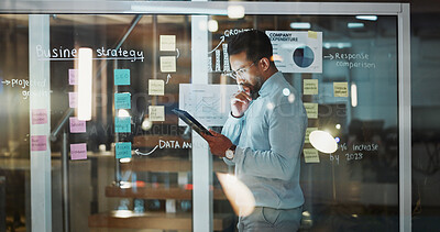 Buy stock photo Thinking, business and man on tablet by window for finance review, budget planning and research. Night, tech and person with sticky notes for profit growth, solution and financial strategy in office