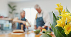 Old couple, cooking and kitchen at house with flowers, romance and gift for celebration. Senior people, meal prep and floral present in home with bouquet, romantic surprise and anniversary milestone