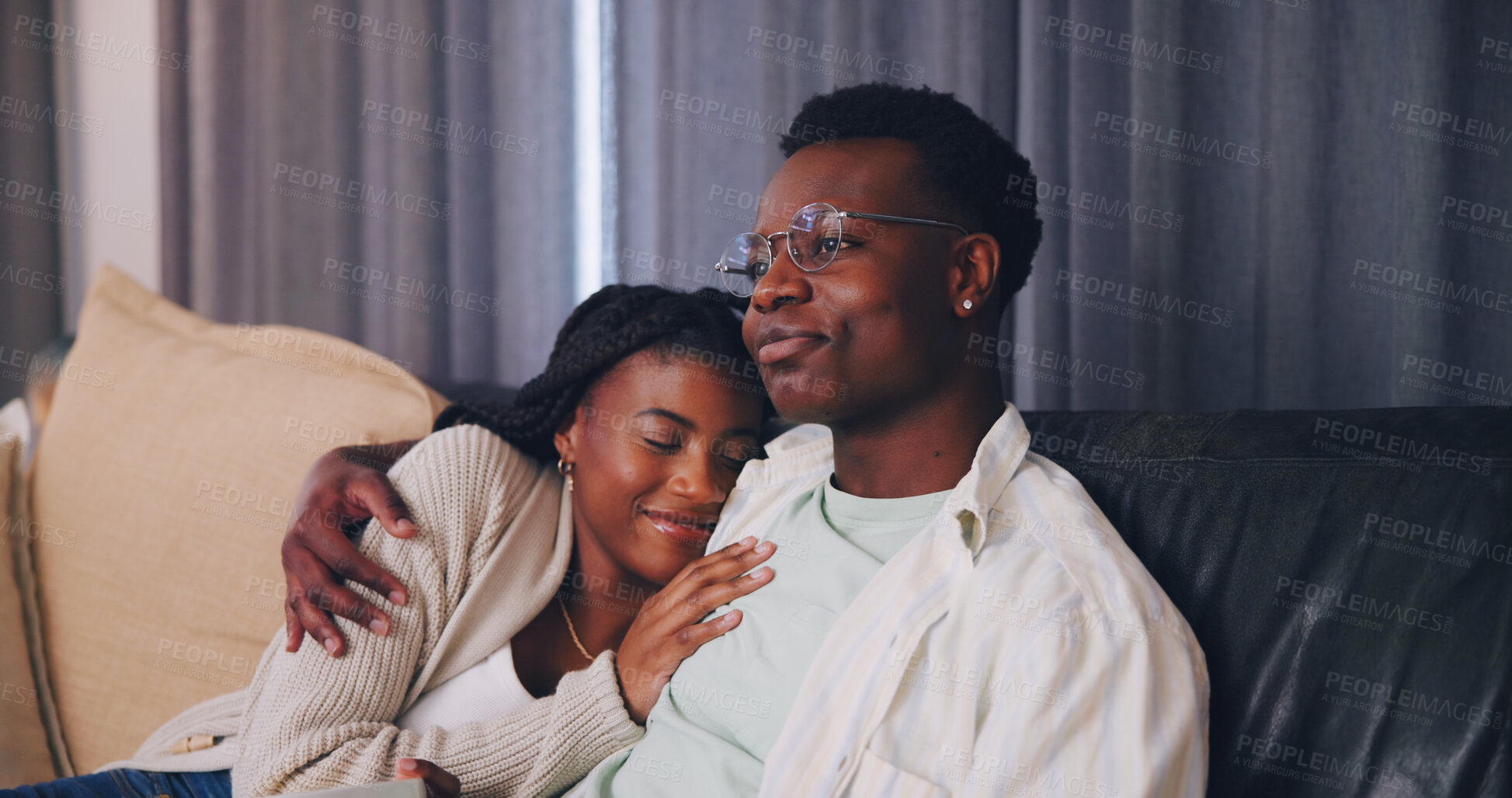 Buy stock photo Couple, cuddle and watching tv with smile in lounge, entertainment and bonding with partner in home. Happy, black people and chilling in living room, embrace and streaming movie with spouse in house