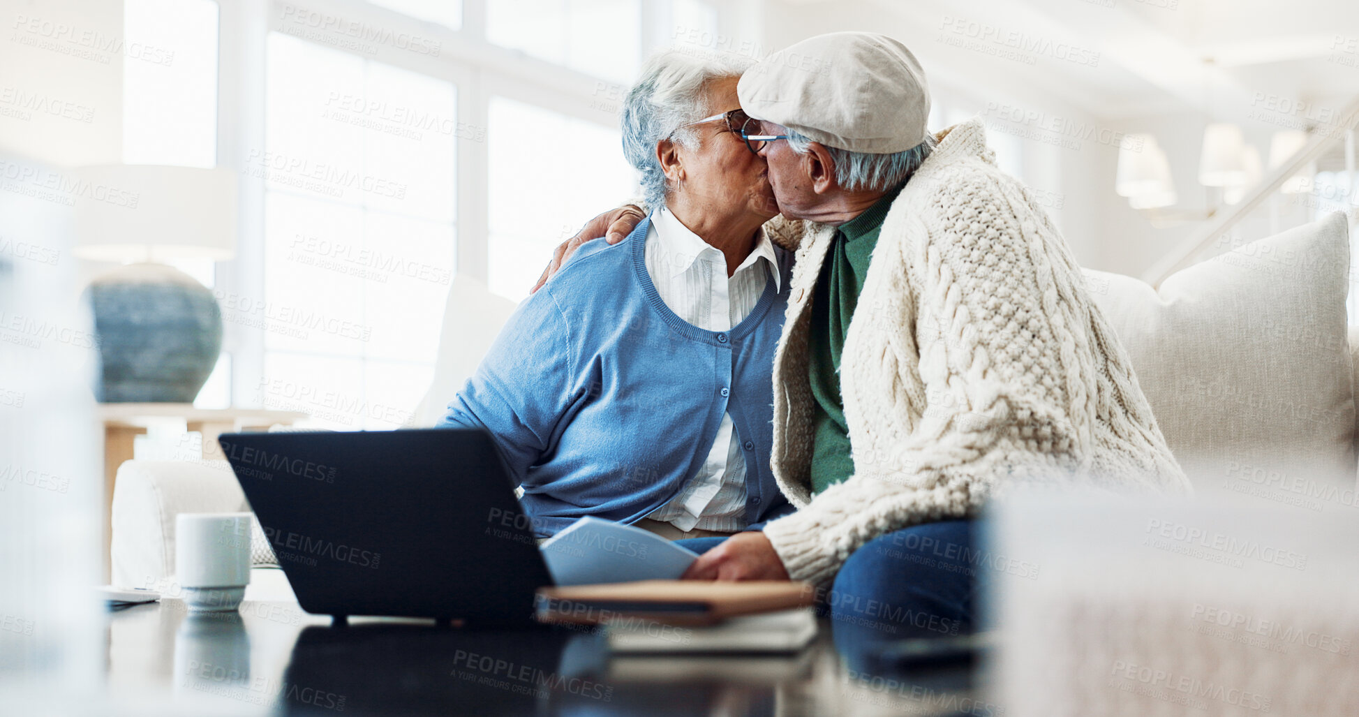 Buy stock photo Kiss, laptop and senior couple on home sofa with document for pension payout, online or retirement. Man, woman or love in house with self service app, policy and fund benefit or old age grant on tech