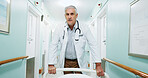 Walking, man and doctor with bed in hospital for ICU, operation or ER healthcare in corridor. Support, serious and mature surgeon with stretcher for surgery or medical service in clinic hallway.