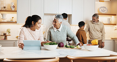 Buy stock photo Happy, family and cooking in kitchen with tablet, meal prep and online recipe for healthy food. Mother, grandmother and digital at house with vegetables, tutorial video and culinary skills for lunch