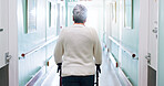 Hospital, healthcare and old person with rollator in hallway, injury or rehabilitation with balance. Clinic, back and senior woman with disability, healing and walking with walker and stroke recovery