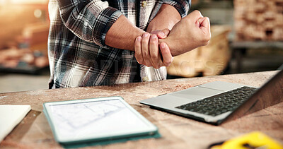Buy stock photo Carpenter, hands and wrist pain in workshop with injury, laptop and fatigue from woodwork operations. Woodworker, man and joint inflammation in carpentry business with computer, tension or arthritis.