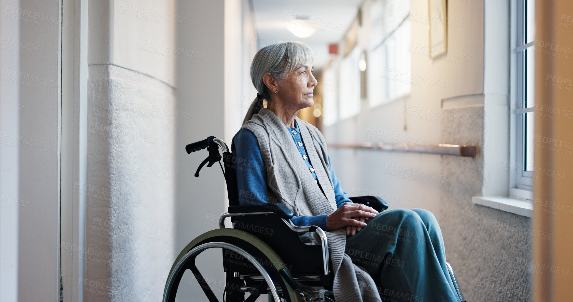 Buy stock photo Corridor, thinking and wheelchair with old woman in retirement home for memories or nostalgia. Flare, remember and senior person with disability at window for contemplation, ideas or morning view