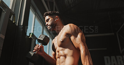 Buy stock photo Dumbbells, exercise and bodybuilder man with music and serious for training, muscle growth and self care. Earphones, workout playlist and person or low angle in gym for fitness, strong and power