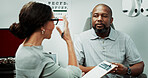Optometry, consulting and man in clinic talking for sight, vision and results for eye exam. Healthcare, clipboard and optician with patient for checkup, medical report and ophthalmology appointment