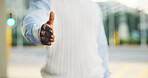Person, meeting or city with handshake for greeting introduction or outdoor acquaintance. Traveler, commute or shaking hands with gesture for thank you, welcome or agreement on sidewalk in urban town
