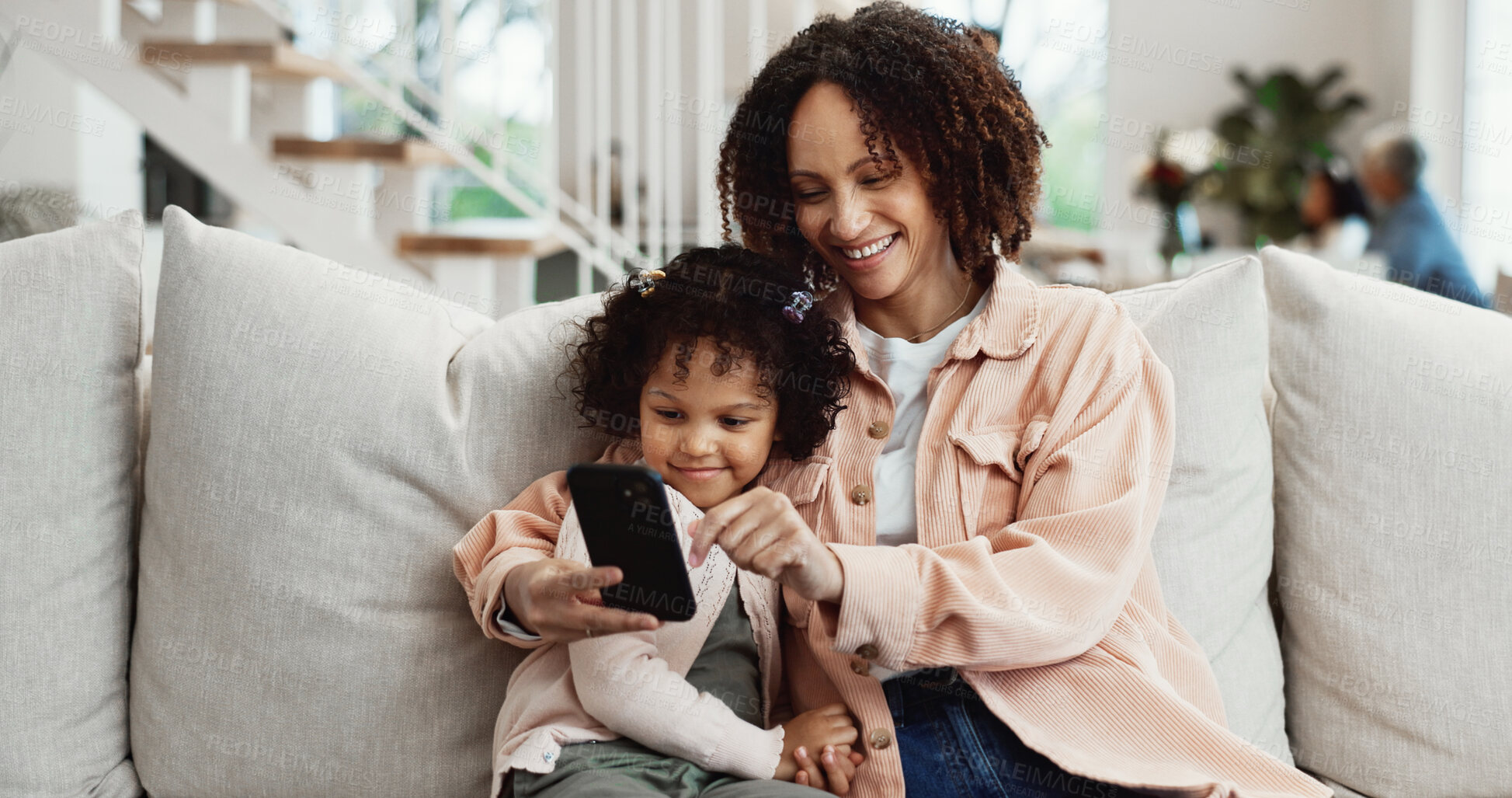 Buy stock photo Phone, mother and child in home with smile, online game or interactive learning with parent. Mobile, girl and happy mom on sofa to play with educational gaming app, relax and daughter in family house