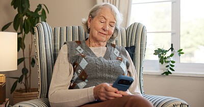 Buy stock photo Phone, smile and elderly woman with texting, reading news and mobile app for contact in home. Senior person, tech and scroll with chat, notification and social network on lounge couch in retirement