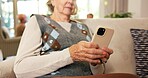 Phone, typing and senior woman in home with texting, email or reading blog on retirement on app. Technology, relax and elderly person with cellphone for chatting on website in living room at house.