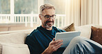 Happy, man and reading at house with tablet, social media and browsing online for latest movies. Smile, mature person and relax in home with digital, internet search and streaming for film watchlist
