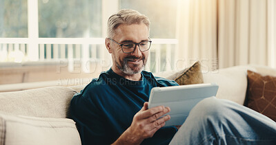Buy stock photo Happy, man and reading at house with tablet, social media and browsing online for latest movies. Smile, mature person and relax in home with digital, internet search and streaming for film watchlist