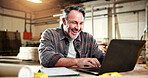 Smile, carpenter and laptop with man in warehouse for construction plan, research and design software. Furniture manufacturing, online project and woodworking with mature person in workshop for craft
