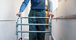Hands, woman and walking at facility with walker, support and mobility aid for injury recovery. Medical, healing and person with disability, gait training and balance assistance for physical therapy