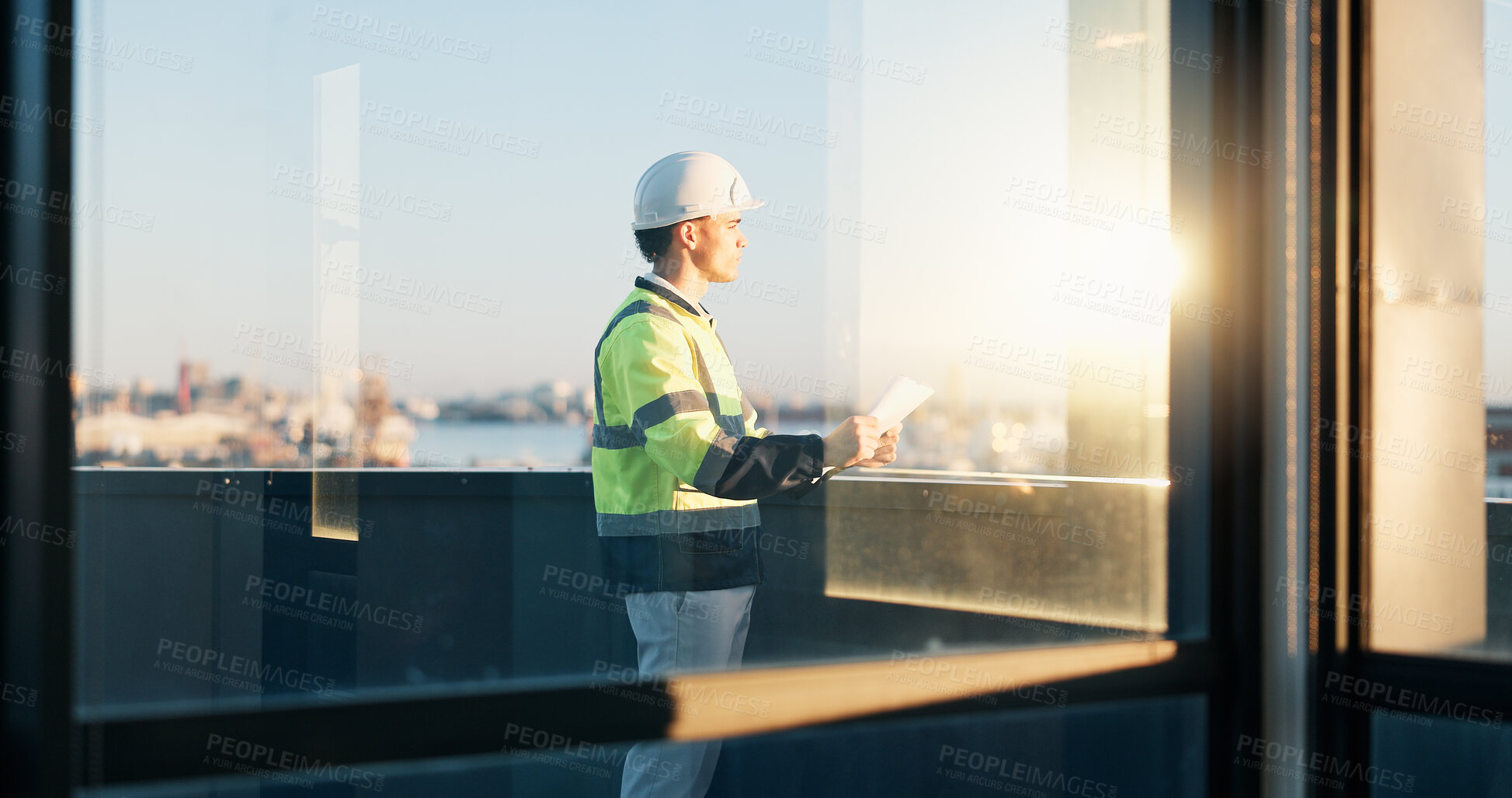 Buy stock photo Man, engineer or reflection on rooftop with blueprint, urban development or view for expansion project. Builder, flare or paperwork at building window for perspective with infrastructure evaluation