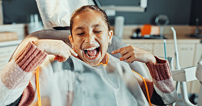 Buy stock photo Teeth, pointing or girl with smile for dental hygiene, oral healthcare or treatment in clinic. Happy, child or kid with gum care or satisfaction for dentist cleaning, exam or appointment on chair
