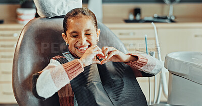 Buy stock photo Patient, dentist and happy girl with heart hands in clinic for dental appointment or healthy teeth. Child, kid or smile with like emoji, shape or satisfaction for oral hygiene, gum care or healthcare