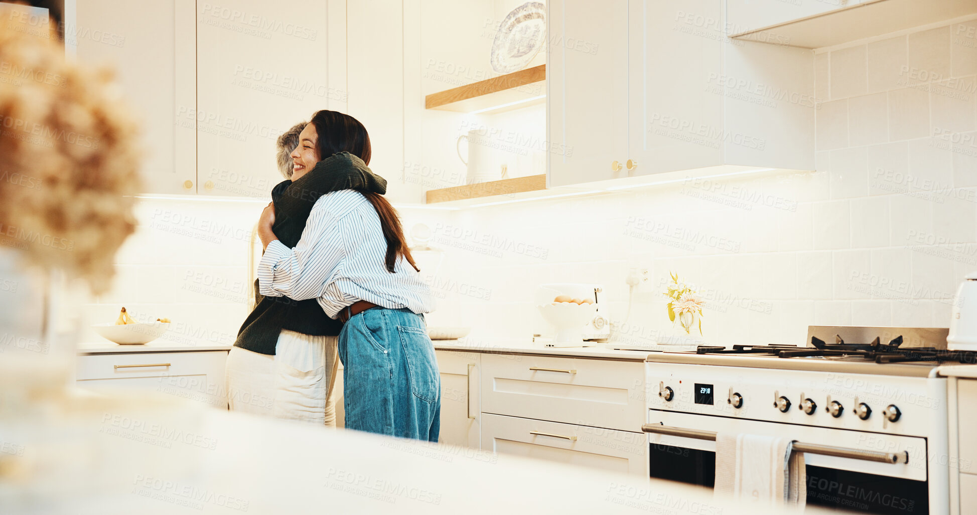 Buy stock photo Hug, happy and woman with senior mother in kitchen at house for bonding, family and connection. Smile, love and adult daughter embracing elderly mom for safety, care and trust in apartment together.
