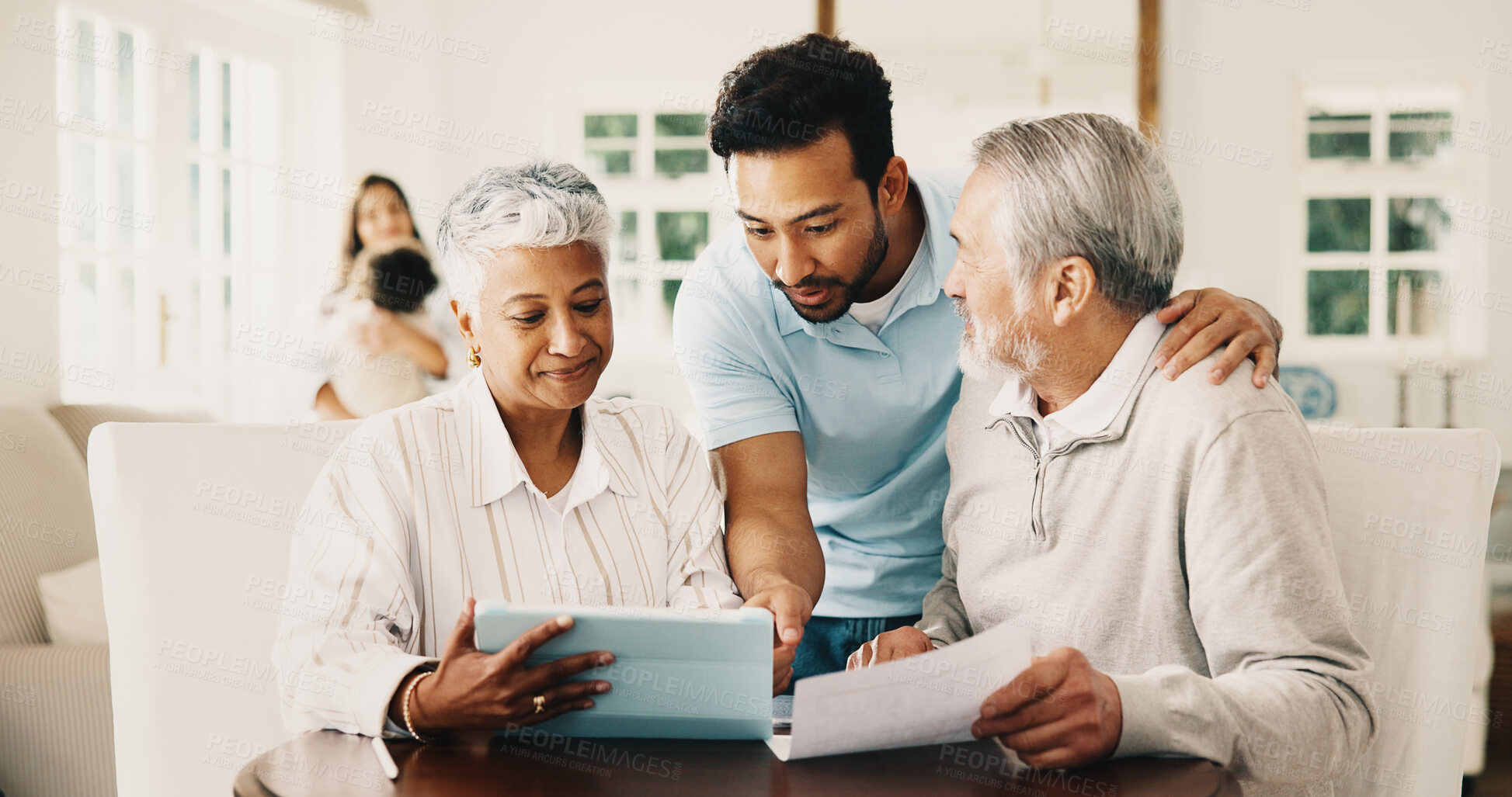 Buy stock photo Man, talk and senior parents with tablet in home, financial planning or budget review with document. Happy, family and old people with son, help and bills with tech, online and discussion in house